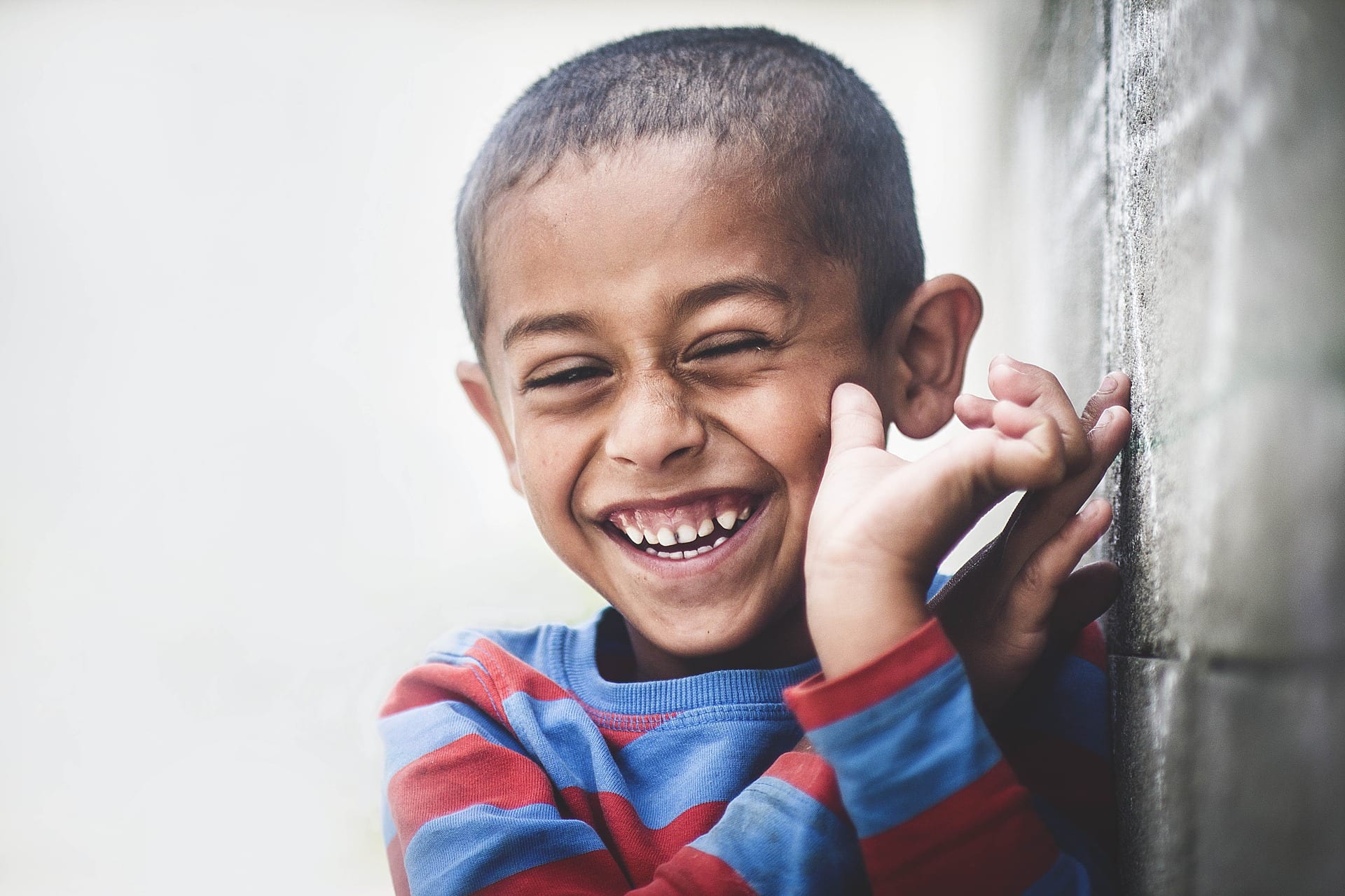 A young boy grinning widely. 