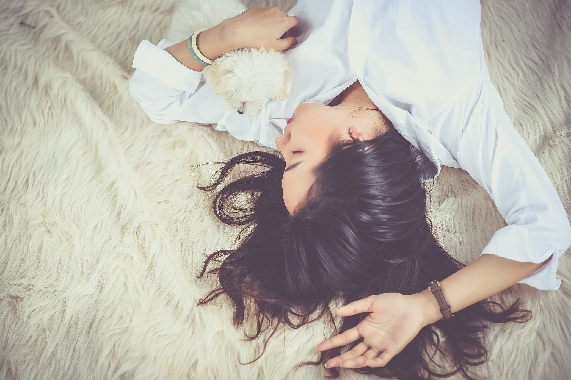 Young woman relaxing with a puppy.