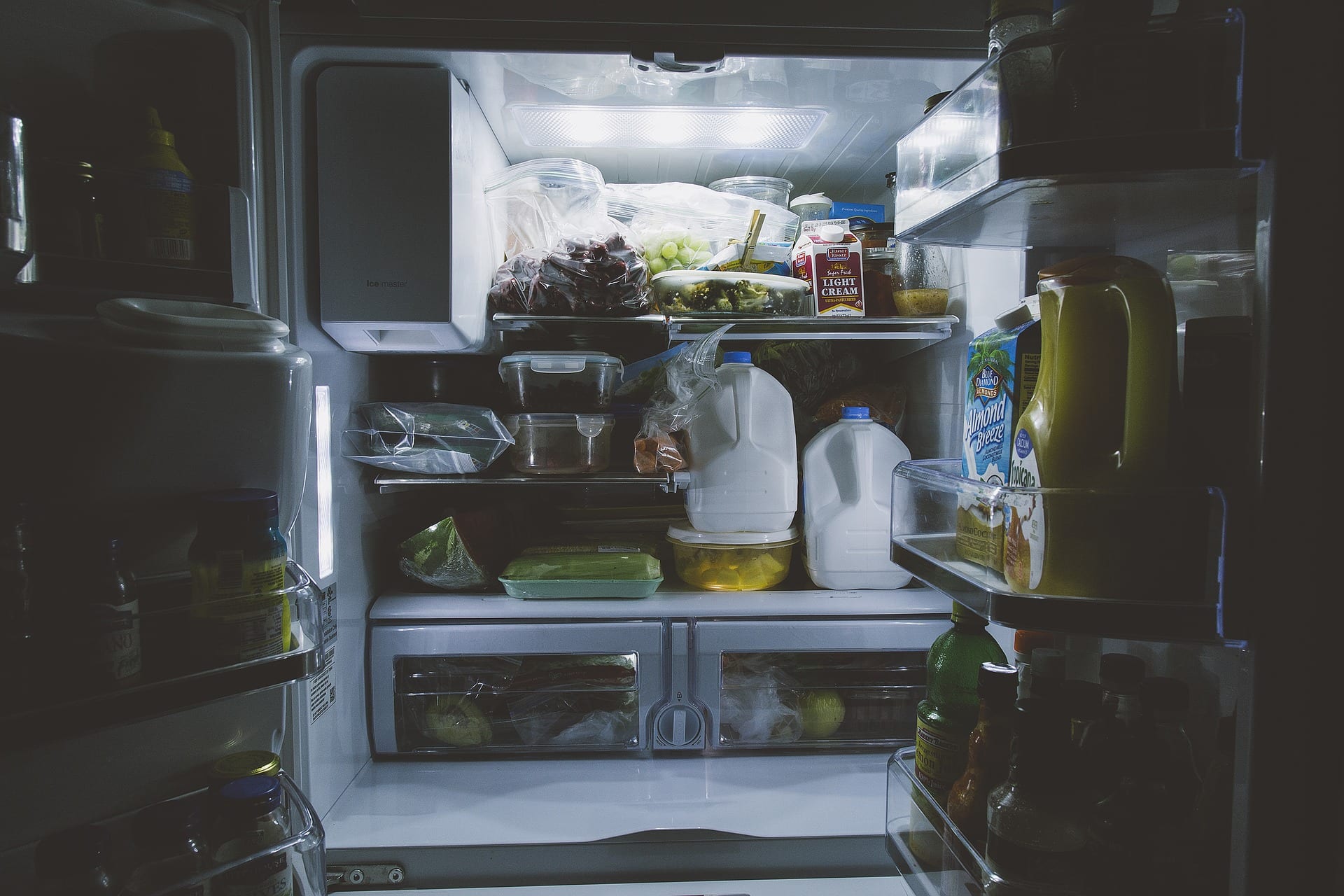 A fridge stocked full of healthy things, presumably being opened at 2 am.