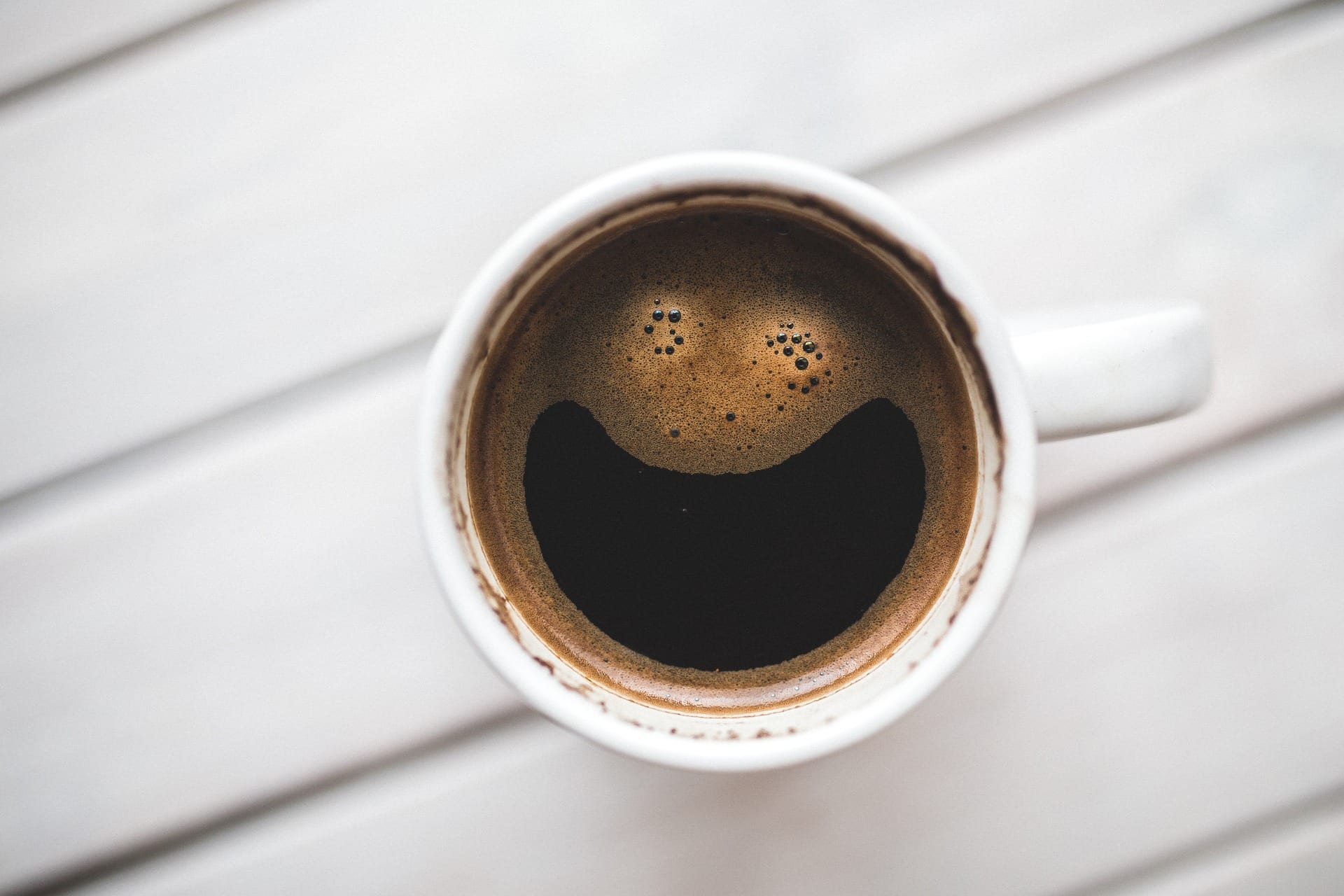 A cup of coffee that's very happy to see you!