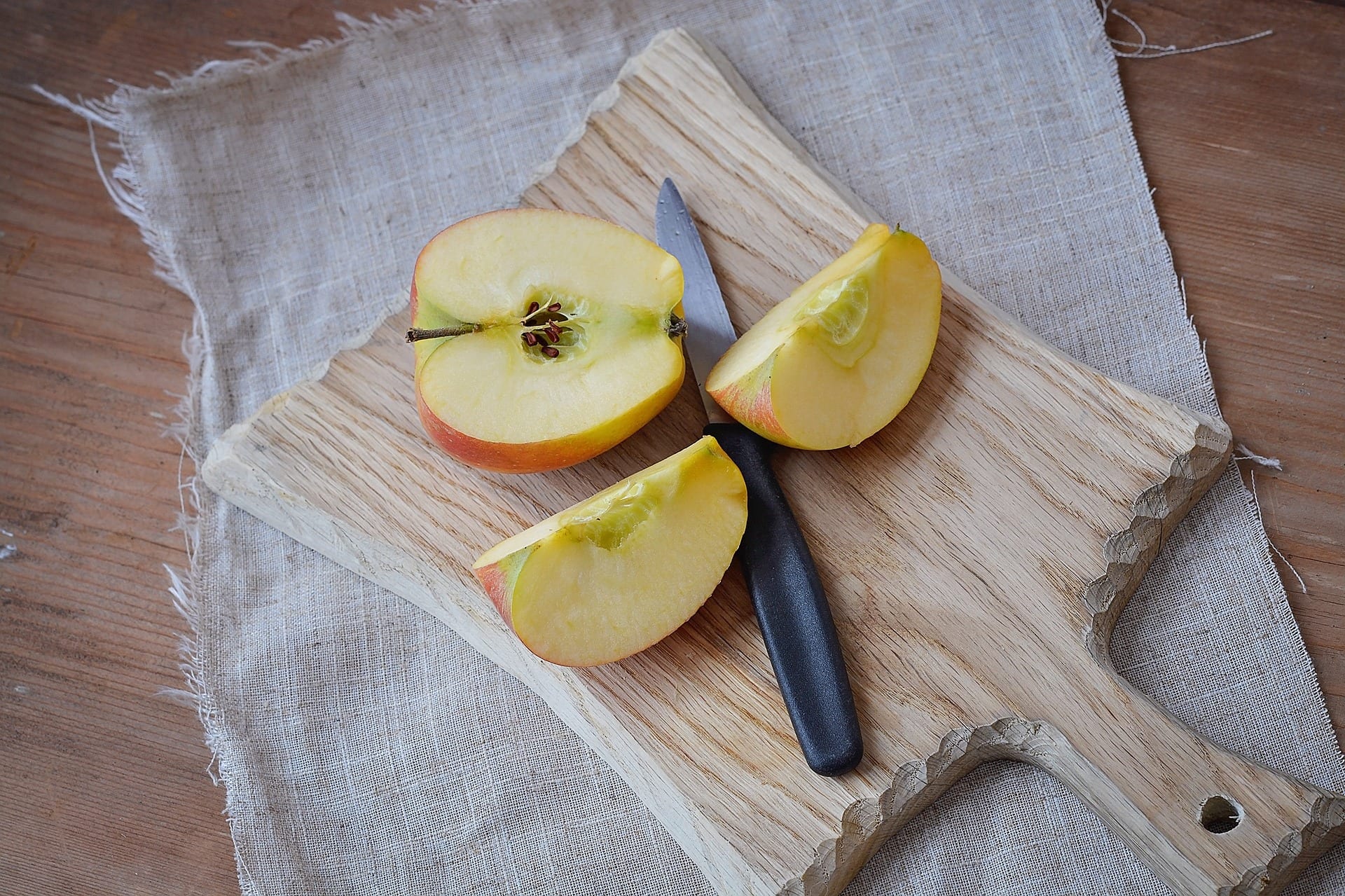 Sliced apple on a wooden cutting board.